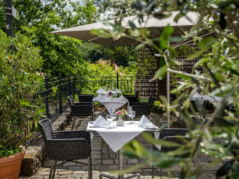 Die Terrasse ist mit einer Hecke umgeben um eine gemütliche Umgebung zu schaffen.