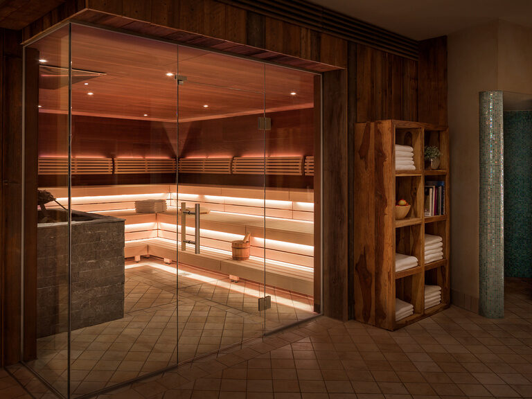 Neben der modernen Biosauna steht ein Holzregal, welches unter anderem Handtücher zur Verfügung stellt