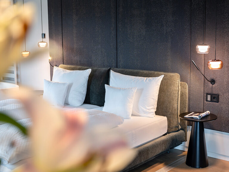 Blumen verdecken einen Teil des großen Doppelbetts in der Skysuite