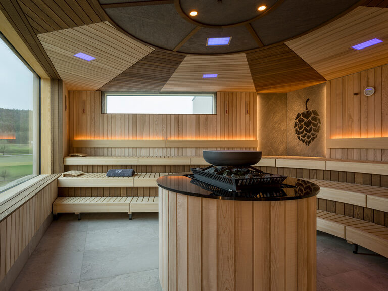 Eine Sauna mit Holzwänden und einem Ofen auf dem Rooftop-Sauna-Deck.