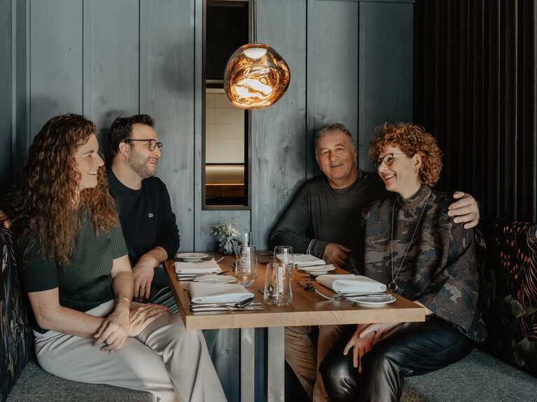 Die Gastgeberfamilie sitzt an einem schön gedeckten Tisch.