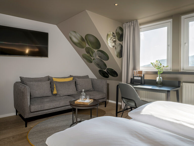Ein geschmackvoll eingerichtetes Wohnzimmer im Superior-Stil mit Sofa und Bett.