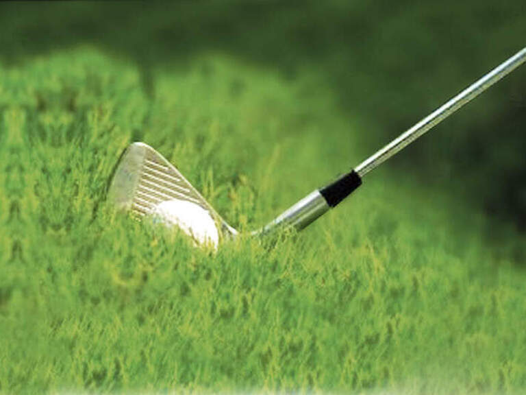 Ein Golfer spielt einen Golfball aus einer Böschung