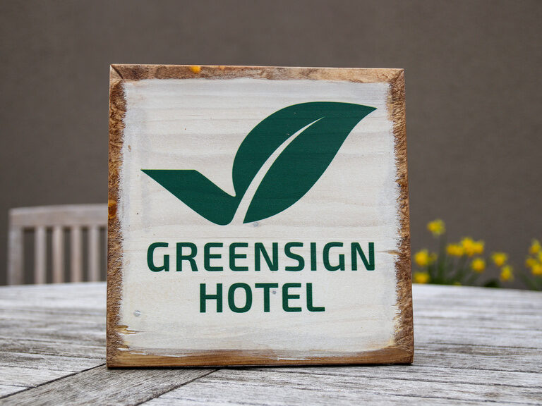 Ein Holzschild auf einem Tisch als grafisches Design-Element für das Hotel.