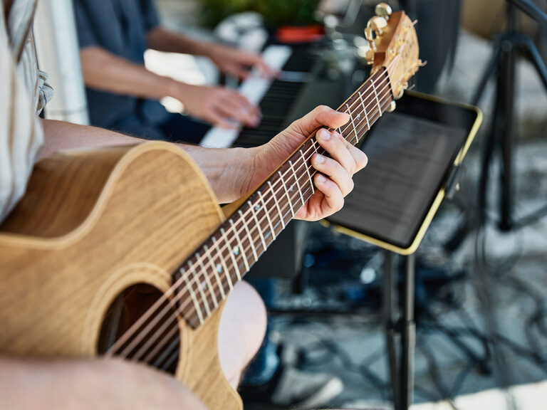Ein Gitarrenspieler neben seinem Kollegen am Keyboard