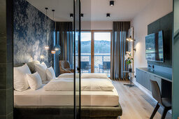 Das Premium Zimmer mit der Duschwand im Vordergrund und einem schönen Ausblick