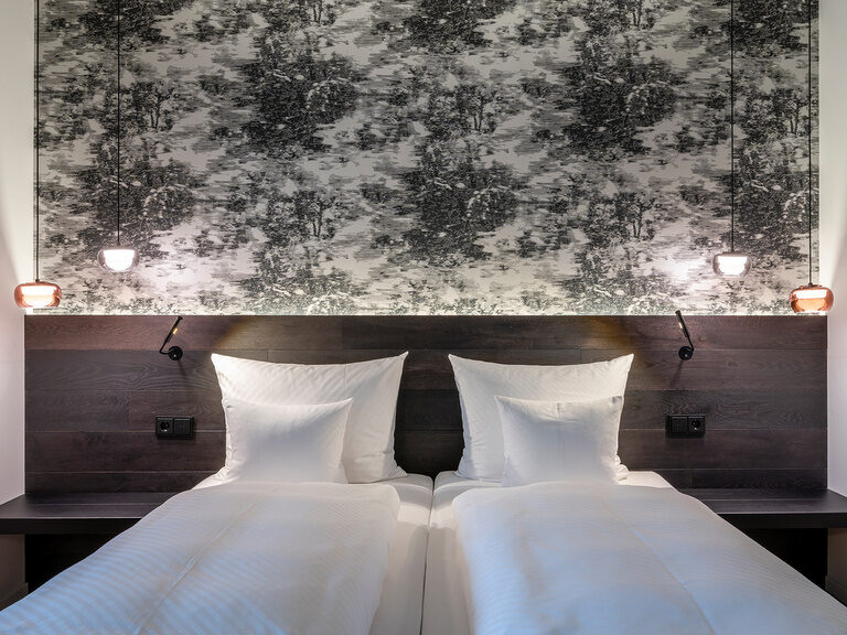 Über dem Doppelbett im Premium Deluxe Zimmer hängt ein Bild das zum Stil des Zimmers perfekt passt.