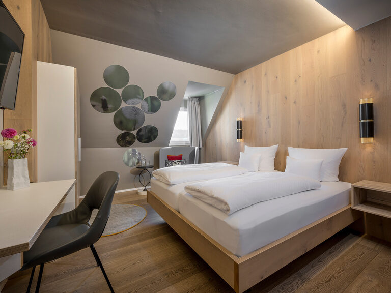 Ein komfortables Bett in einem modernen Hotelzimmer lädt zum Entspannen ein.