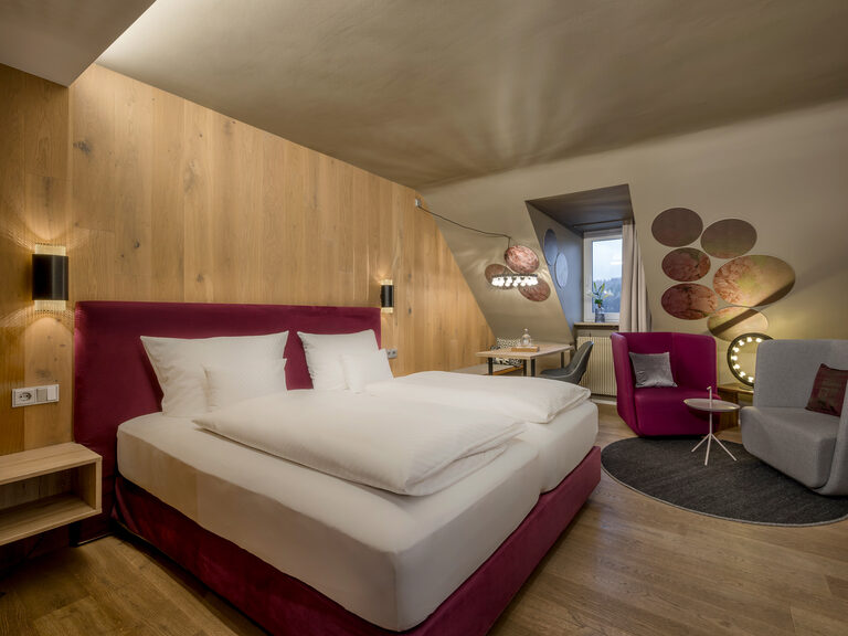 Ein komfortables Bett mit hochwertiger Matratze im Superior Zimmer mit stilvollem Schreibtisch.