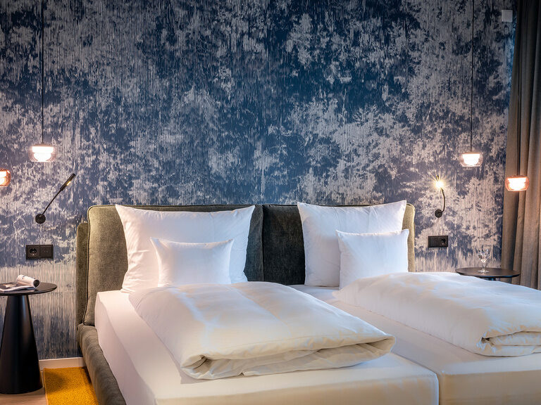Zwei Betten sind zum Doppelbett der Sky-Suite-Deluxe im Wellnesshotel zusammengeschoben