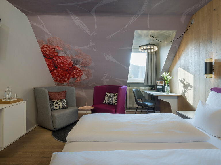 Ein gemütlich gestaltetes Hotelzimmer mit zwei Betten und einem Fernseher.