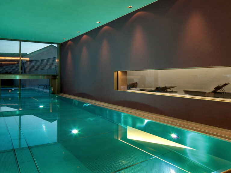 Ein stilvoll entworfener Innenpool mit modernen Beleuchtungselementen im Wellnesshotel