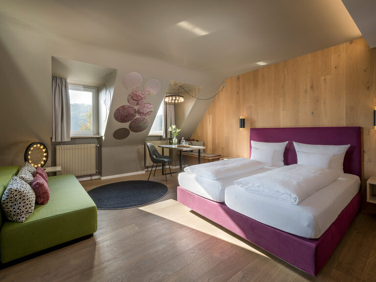 An der Holzwand ist das Doppelbett neben den Fenstern im Superior Zimmer