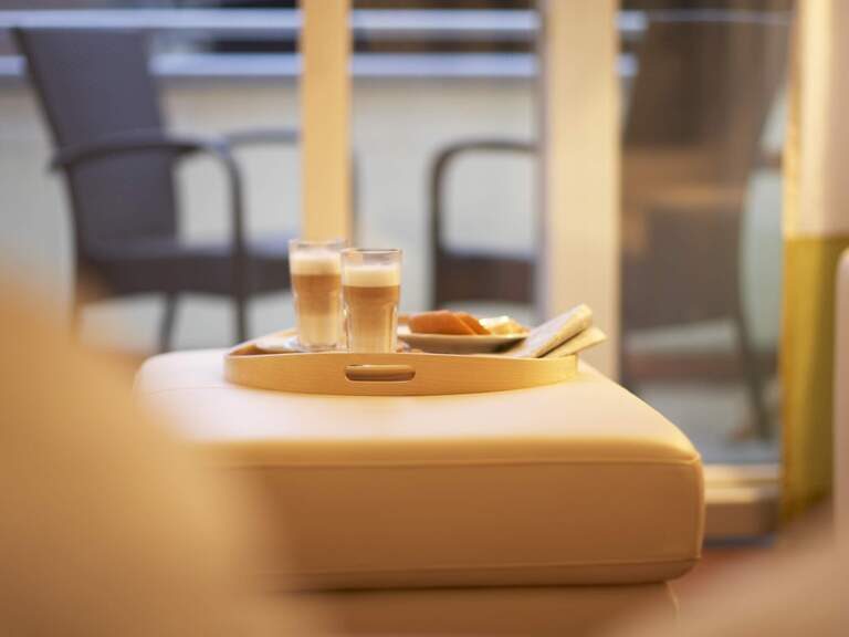 Zwei Gläser Kaffee stehen auf dem Couchhocker im Deluxe Doppelzimmer