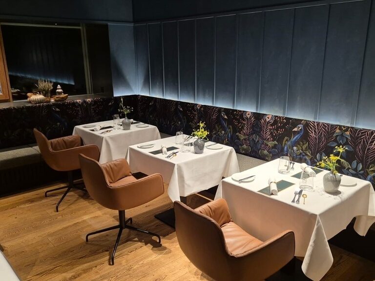 Drei Tisch stehen in dem noch leeren Restaurant gedeckt, bevor die Abendgäste die Gaststube betreten.
