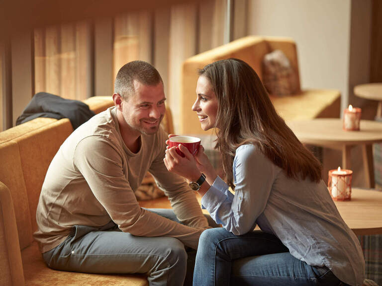 Ein Paar unterhält sich beim Kaffeetrinken in der Lobby