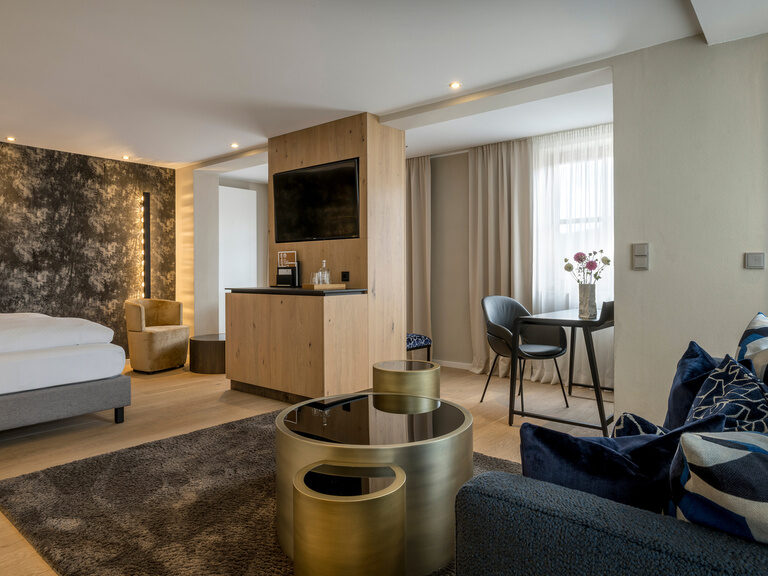 Die moderne Einrichtung des Premium Deluxe Zimmers punktet neben dem großen Bett mit einem Flatscreen-TV und einem gemütlichen Sofa.