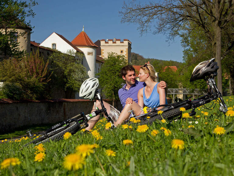 Ein Paar macht in einer Wiese eine Pause während ihrer Radtour