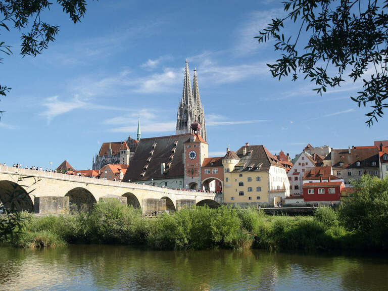 Eine Brücke führt über einen Fluss in die Stadt Regensburg