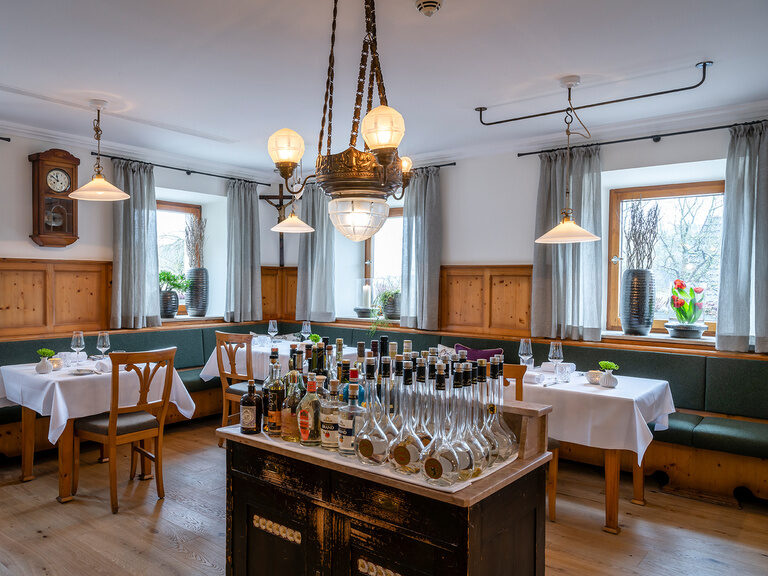 Auf einer Anrichte in der Gaststube des Hotels stehen eine Menge Flaschen, bereits für das Abendessen vorbereitet.