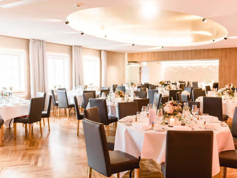Ein Saal ist für eine Hochzeit vorbereitet und dekoriert