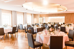 Ein Saal ist für eine Hochzeit vorbereitet und dekoriert