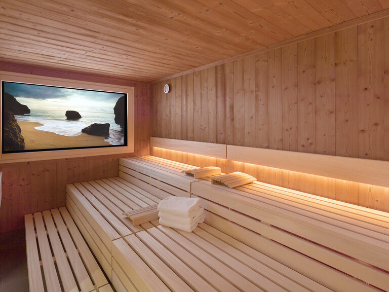 Der Bildschirm in der modernen Aroma Sauna zeigt einen traumhaften Strand