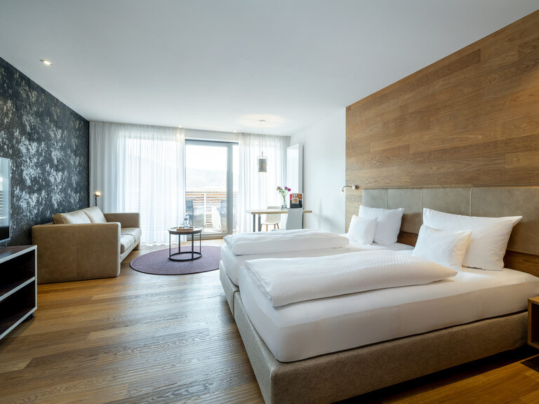 Das Doppelbett im Grand-Deluxe Zimmer wird durch das große Fenster helle beleuchtet