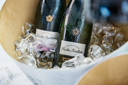 In einer Eisschale liegen Champagnerflaschen
