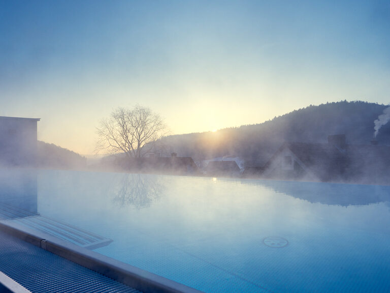 Der große Skypool im Wellnesshotel dampft an einem kalten Wintermorgen