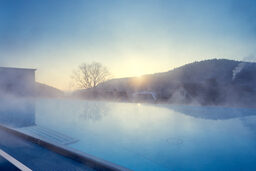 Der große Skypool im Wellnesshotel dampft an einem kalten Wintermorgen