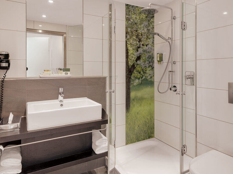 Ein elegantes Badezimmer mit Dusche, Toilette und Waschbecken in einem Superior-Zimmer.