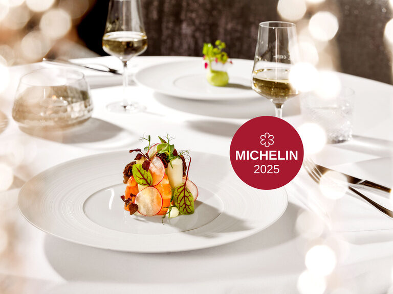 Der weiß gedeckte Tisch und die angerichtete Leckerei hebt die Qualität und den Stil des 2025 mit einem Michelin Stern ausgezeichnete Restaurant Cheval Blanc hervor.