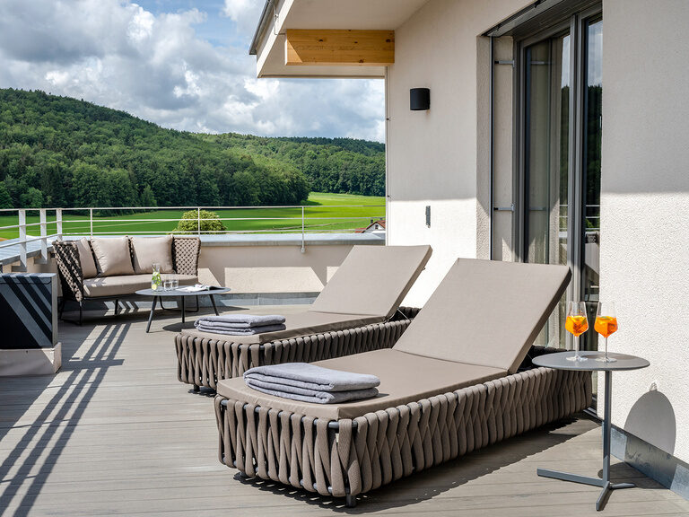 Der schöne Ausblick von den Liegen des Balkons der Skysuite über die schöne Landschaft rund um das Wellnesshotel