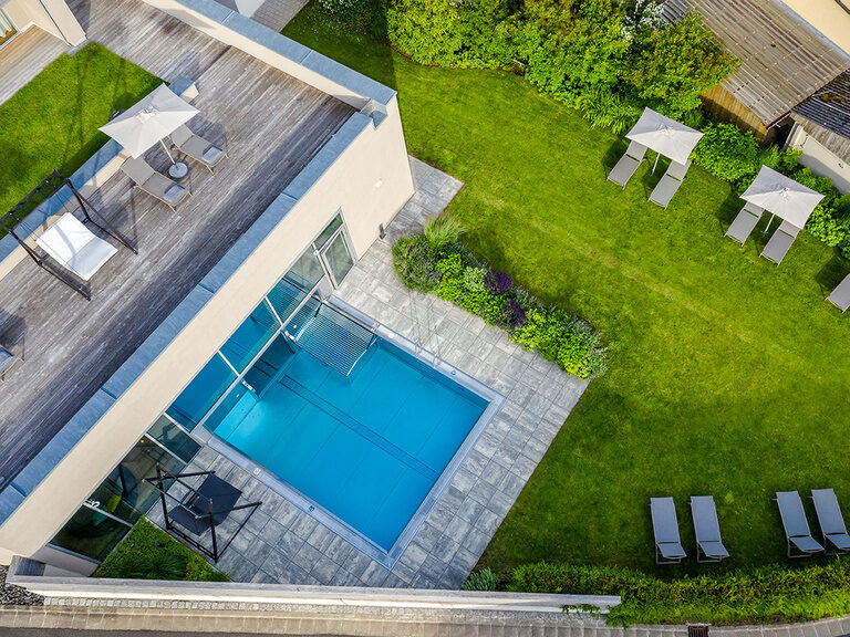 Eine Top-Down Ansicht auf den Aussenpool und die Terrasse des Hotels