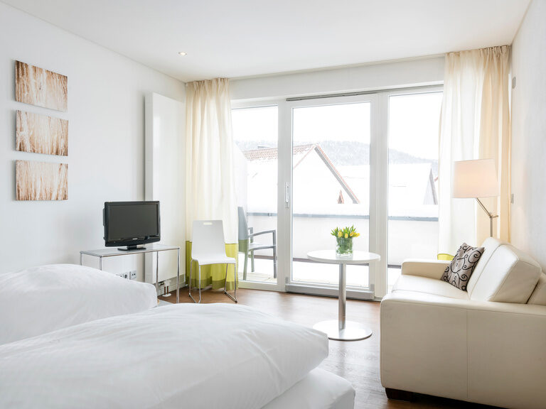Das Deluxe Doppelzimmer ist im weißen Stil gehalten und mit beigen und gelben Akzenten versetzt