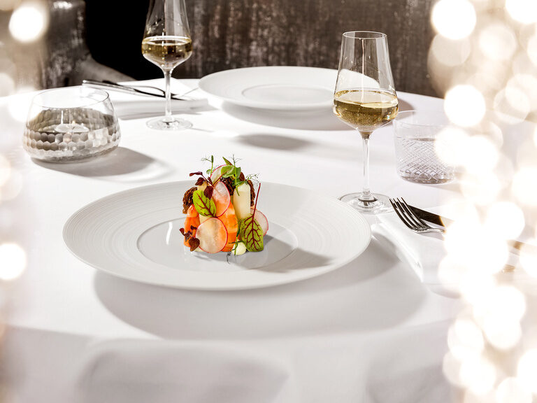 Ein weißer Tisch mit Gläsern gefüllt mit Wein und Tellern