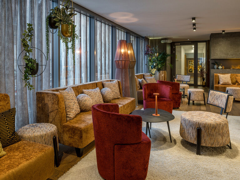 Ein stilvoll eingerichtetes Wohnzimmer mit Couch und Sesseln im Aufenthaltsbereich